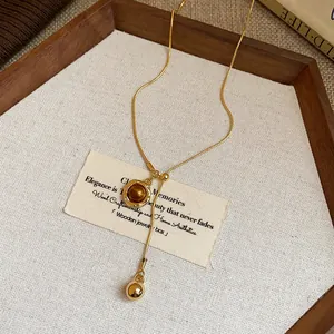 Close-up of retro resin pendant necklace with adjustable gold chain on wooden tray