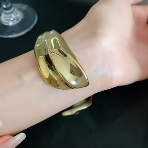 Macro view of a stylish chunky gold-tone irregular pleated acrylic cuff bracelet