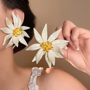 Close-up of 3D white flower earrings with yellow center for summer beach vacation