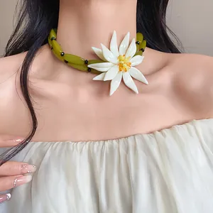 Close-up of a 3D white flower choker necklace with green olive beads for beach vacation