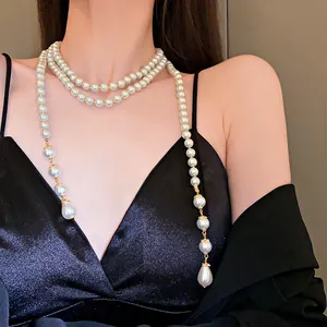 Detailed view of an elegant multi-layer long pearl necklace with teardrop pendants