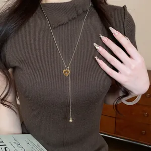 Elegant gold lariat necklace with a brown heart pendant for autumn fashion styles.