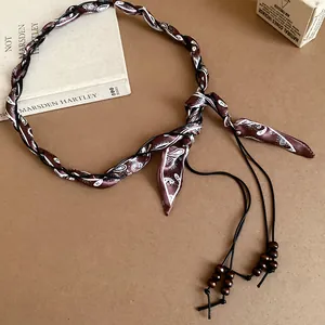 Detail view of Bohemian woven waist chain with paisley scarf and wooden beads