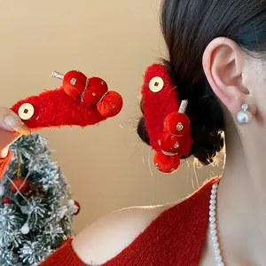 Detail of festive red flocked candied haw hair clip worn on hair and held in hand.