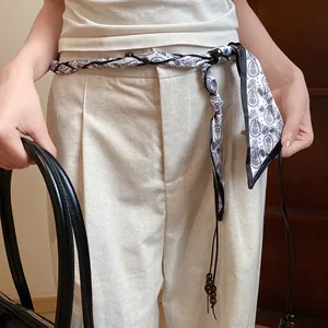 Close-up of a bohemian silk scarf braided waist chain with elegant wooden beads