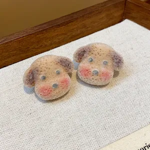 Close-up of cute flocked puppy dog stud earrings with soft fuzzy texture.
