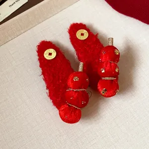 Close-up of red flocked tanghulu hair clips with gold star details for New Year.