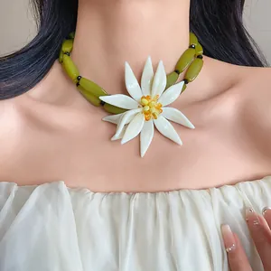 Exaggerated white 3D flower choker necklace with green olive beads shown on model
