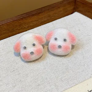 Close-up of cute white puppy resin stud earrings with pink accents