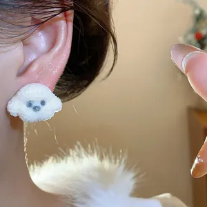 Close-up detail of a cute white fuzzy puppy dog stud earring worn on the earlobe