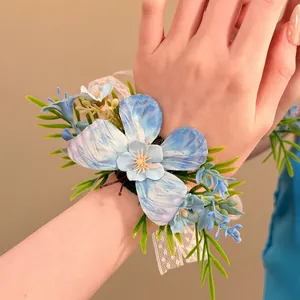 Close-up detail of an elegant blue fabric flower wrist corsage with lace on a hand