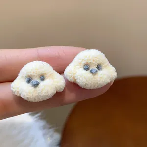 Close-up of cute flocked puppy stud earrings with soft texture and silver needles