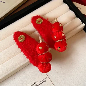 Detailed view of red flocking sugar gourd hair clips with gold coins and star sequins.