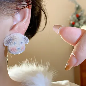 Detailed macro view of a cute resin dog-shaped earring with a fuzzy flocked texture.