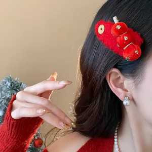 Close-up of red flocked hawthorn hair clip worn on black hair for New Year festival