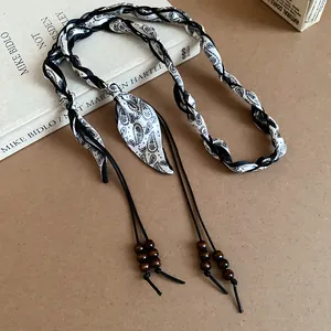 Artistic close-up of bohemian woven silk scarf waist belt with wooden bead details