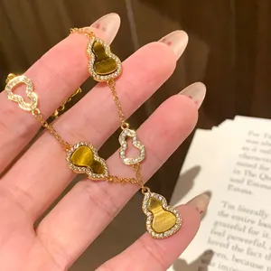 Elegant gold bracelet featuring zircon-encrusted gourd charms and tiger eye stones.