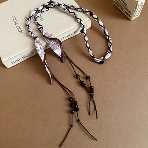 Detailed view of bohemian silk scarf braided waist chain with dark wooden beads