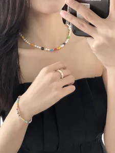 Colorful beaded flower necklace with pearls, sweet girly style detail shot on model.