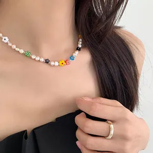 Detailed view of a sweet colorful beaded flower and pearl necklace on a female model