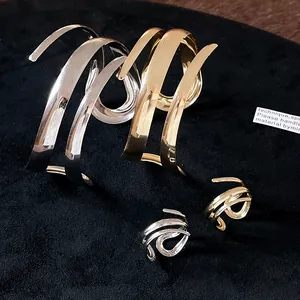 Dettaglio macro di un set coordinato bracciale e anello geometrico in oro e argento