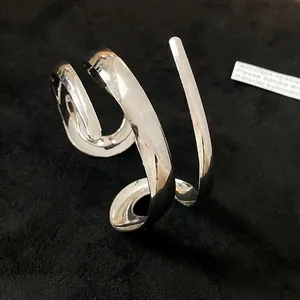 Dettaglio ravvicinato della finitura a specchio di un bracciale rigido geometrico argento lucido