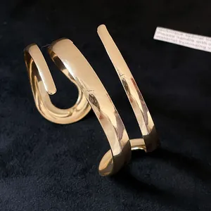 Primo piano di un bracciale a fascia geometrico dorato minimalista su velluto nero