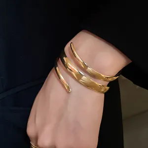 Vista dettagliata di un bracciale a spirale in oro lucido su un polso di una donna