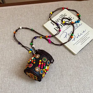 Detail of Bohemian coconut shell necklace with colorful beads on an artistic book background.