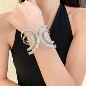 Irregular geometric hollow textured open cuff bracelet in silver worn by a model