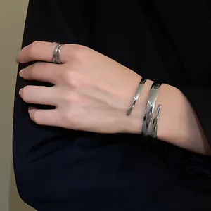 Dettaglio di un bracciale a fascia geometrica argento minimalista e anello coordinato