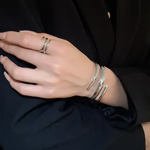Vista dettagliata di set anello e bracciale aperti geometrici in argento