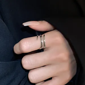 Primo piano di un anello a spirale in argento minimalista con design geometrico sul dito