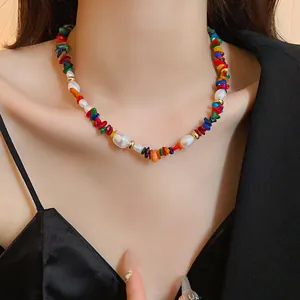 Gros plan détaillé d'un collier en éclats de pierres multicolores et perles blanches sur un mannequin