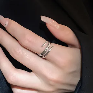 Ripresa macro dettagliata di un anello aperto a spirale geometrica argentata su una mano