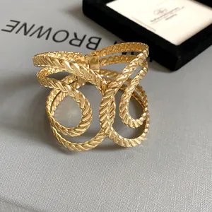 Detailed macro view of a gold geometric openwork cuff bracelet with unique woven texture