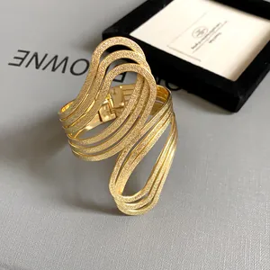 Detail view of a gold geometric hollow textured cuff bracelet with matte finish.