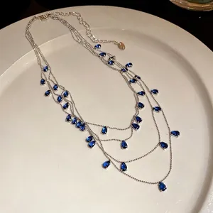 Elegante collar de varias capas con brillantes circonitas azules en forma de gota