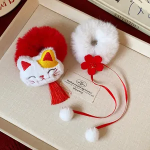 Dettaglio di elastici per capelli in peluche rossi e bianchi con gatto e fiori carini
