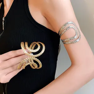 Close-up of model wearing textured gold and silver geometric open cuff bracelets on arm