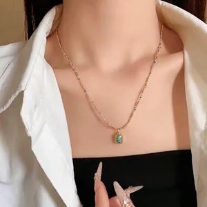 Collier vintage en or avec pendentif rectangulaire en turquoise porté par un mannequin