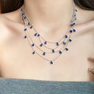 Primer plano de collar plateado de varias capas con colgantes de circón azul brillante.