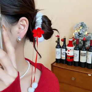 Dettaglio di un elastico per capelli con fiori floccati rossi e accenti in finta pelliccia