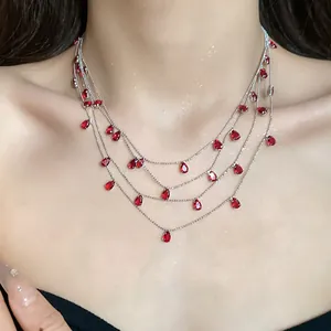 Vista detallada de un collar de plata multicapa con elegantes circonitas rojas en forma de pera