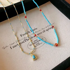 Détail de deux colliers vintage en perles de turquoise exposés sur un plateau à bijoux.
