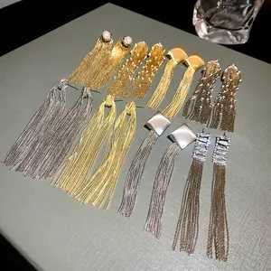 Long metal tassel drop earrings in silver and gold finishes with minimalist design.