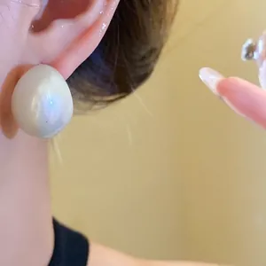 Minimalist oversized acrylic drop earrings with a lustrous cream finish for a modern look