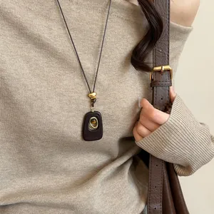 Detail view of retro long necklace with tiger eye stone and dark brown resin pendant