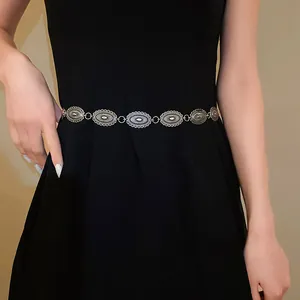 Vintage ethnic silver metal carved oval waist chain belt shown on a black dress model