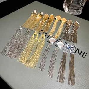Detailed view of multiple gold and silver long metal tassel earrings on display